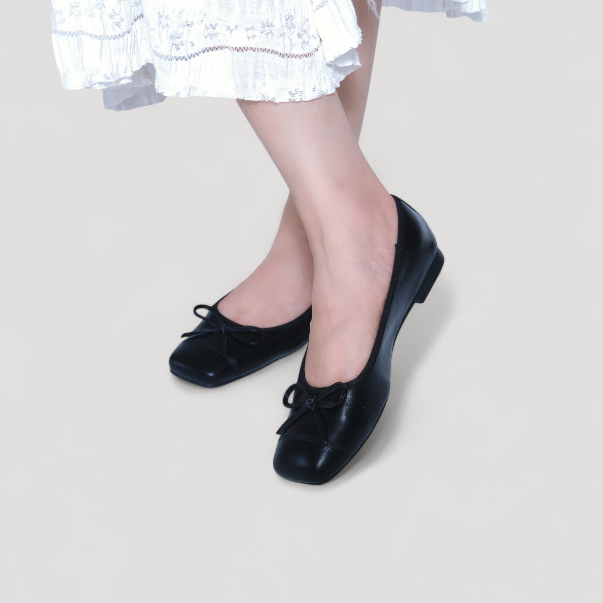 black bow square toe leather ballet flats model posing view