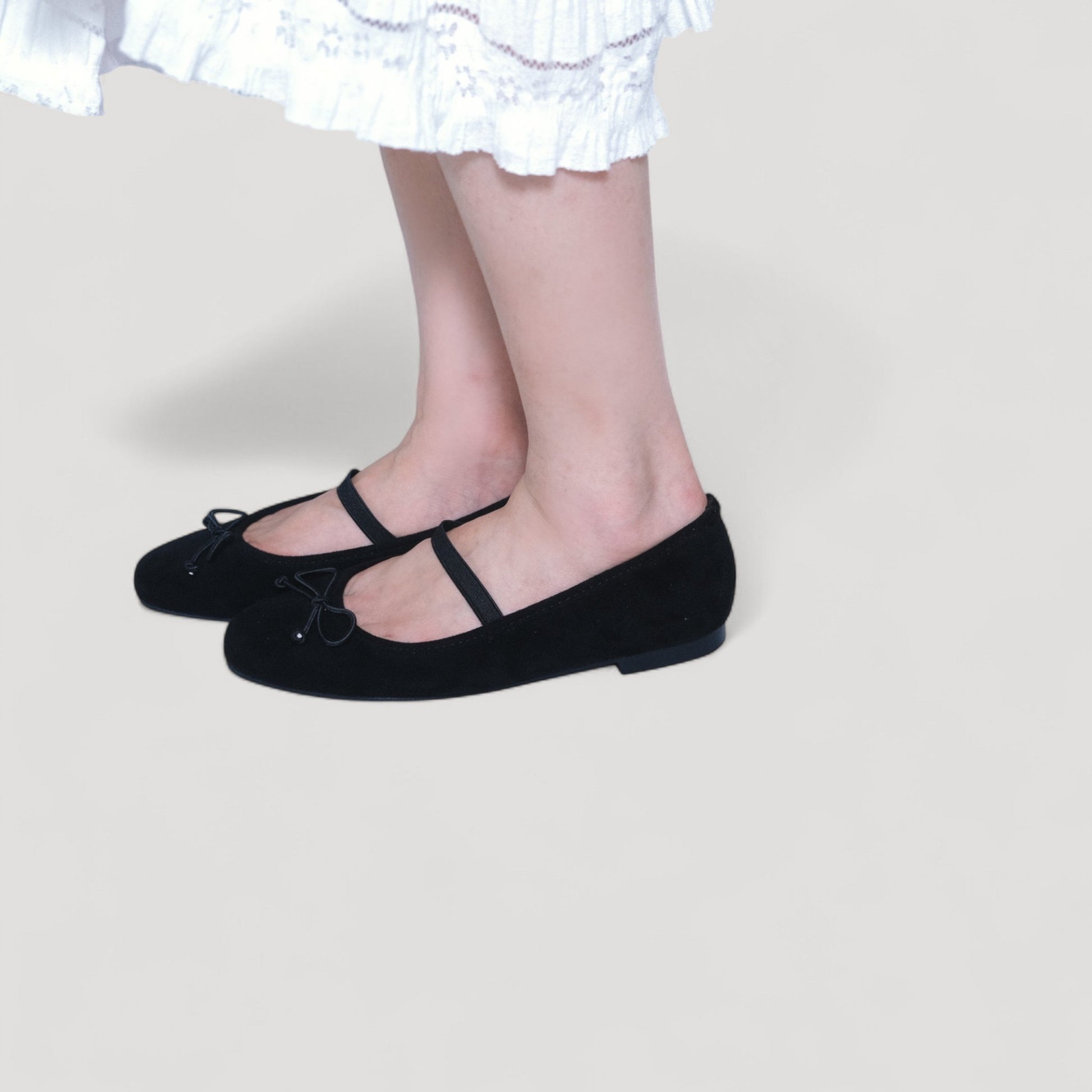 black suede almond toe flats model standing view