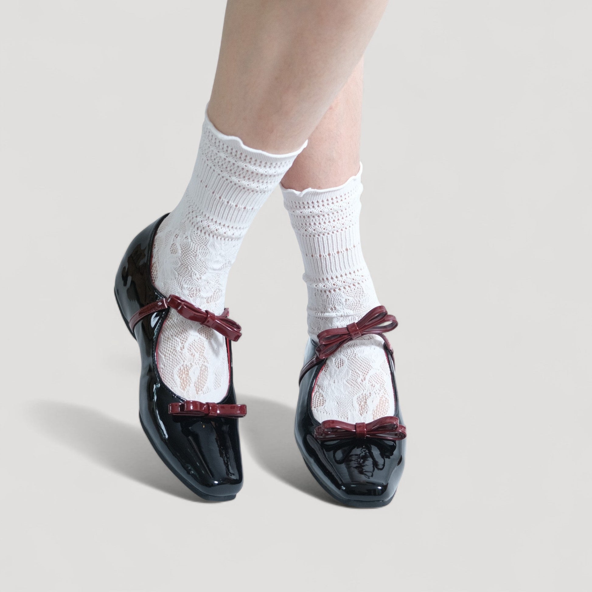 black patent mary jane bow flats model posing  